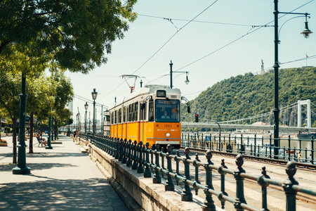 Hungary, Budapest. 15 JUNE 2022. Yellow tram on the Danube river bank in Budapest on a nice summer sunny day.のeditorial素材