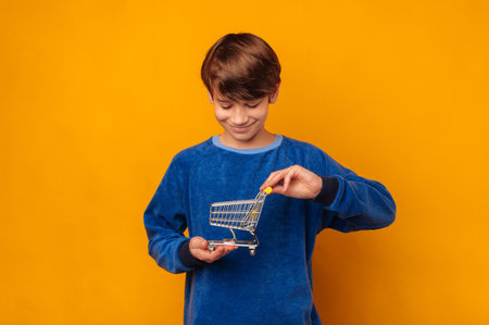 Smiling boy wants to learn about financials while holding a shopping trolley.の写真素材