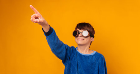 Banner size shot of teen boy wearing pilot glasses and pointing to the future.の写真素材