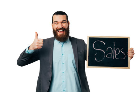Cheerful man is holding thumb up and a blackboard with word sales on it.の写真素材