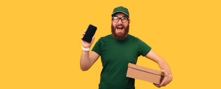 Banner shot of a man holds a box he has to deliver and shows his phone screen.