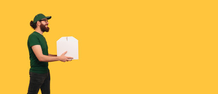Banner size shot of a delivery man wearing green uniform handing a cake box.の写真素材