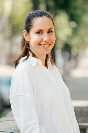 Beautiful close up portrait of a wide smiling young woman in white shirt.の写真素材