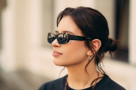 Portrait of a young woman looking aside while wearing black sunglasses.の写真素材