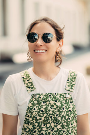 Vertical close up portrait of a wide smiling woman wearing sunglasses.の写真素材