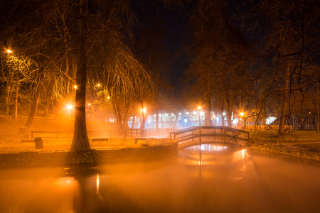 Beautiful night scene with a wooden bridge over the lake illuminated by lights in Cave Bath of Miskolctapolca, Hungaryの写真素材