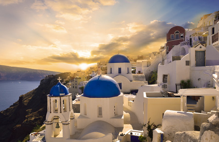 Beautiful travel scene in Oia Santorini village with vibrant sunset illuminating the buildingsの写真素材