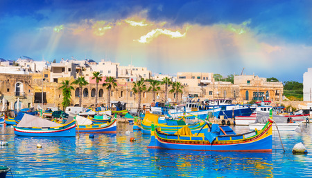 Marsaxlokk village harbor of Malta, illuminate by sunset lightの写真素材