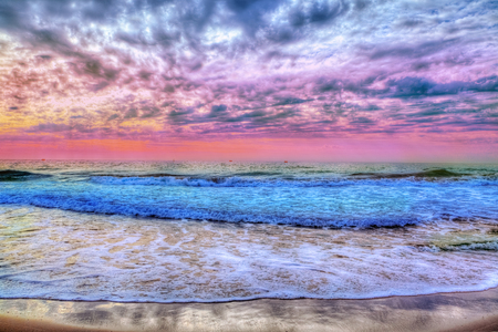 Amazing background with sunset over the beach and colorful clouds and seaの写真素材