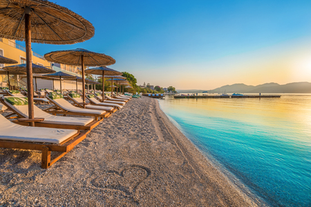 Beautiful view over the beach Nikiana with chairs, umbrellas and a heart drawing on sand, in Lefkada island, Greeceの写真素材
