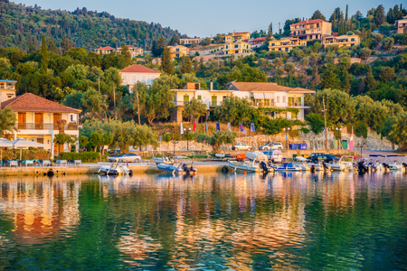 Traditional Greek architecture and boats illuminated by sunrise light on Nikiana beach, Lafkada island of Greeceの写真素材
