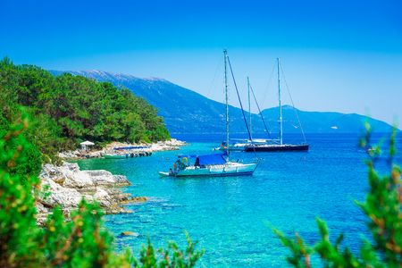 Seaside with boats and mountain in background in Lefkada island, Greeceの写真素材