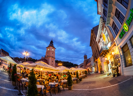 Brasov, Romania - June 3, 2018:  Night life scene in the town with illuminated landmark architecture and people on terracesのeditorial素材