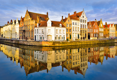 Beautiful Bruges architecture reflected in the canal, illuminated by the sunrise lightの写真素材