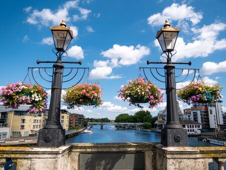 Ornamental flowers and medieval lamps on the wall of Kingston bridge in a sunny dayの写真素材
