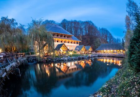 Night scene of Maramures with traditional house reflected in a pond in Sighetu Marmatiei - Romaniaの写真素材