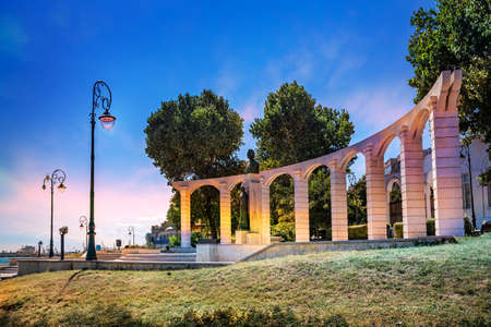 Historical Roman Colosseum illuminated in evening lights on the coast of the Black sea in Constanta city, Romaniaのeditorial素材