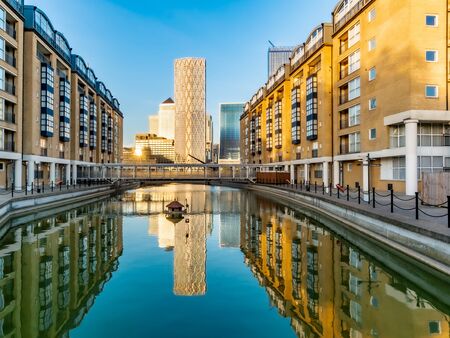 Financial district buildings in Canary Wharf area of London reflected in a lake の写真素材