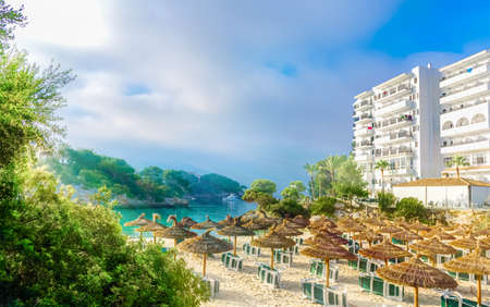 Top view over the beach and umbrellas on Cala Ferrera resort at sunrise on Mallorca island - Spainのeditorial素材