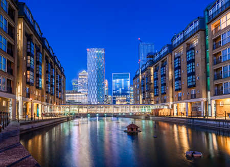 Night scene of the Canary Wharf financial buildings and residential houses reflected in the river Thamesのeditorial素材