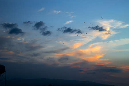 colorful sunset landscape with clouds and birdsの写真素材