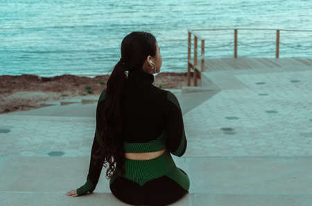 woman listening to music looking at the seaの写真素材