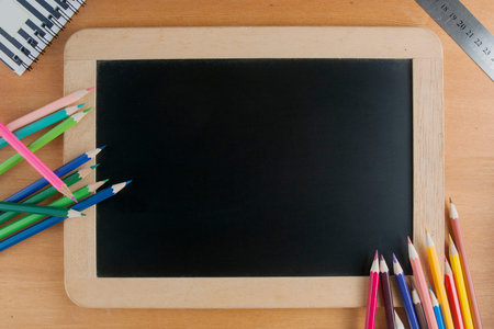 Back to school concept: a slate with pencils along with a ruler and a note: back to school concept