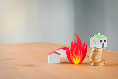 Paper houses that burns and a safe house over a coin pile: fire insurance concept