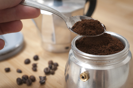 Hand put fresh ground coffee into an italian moka potの写真素材