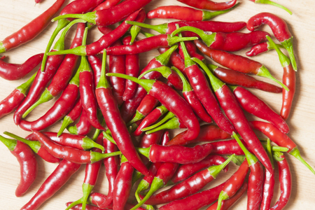Ripe red chili peppers on wooden tableの写真素材