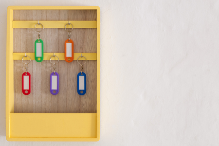 Yellow key holder box with colorful keychains hangingの写真素材
