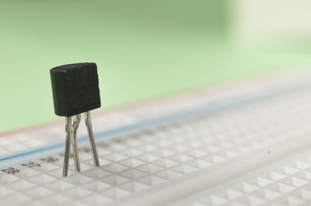A NPN bc239 transistor connected to a breadboard on green backgroundの写真素材