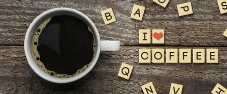Cup of coffee on wooden table with plastic letters text: I love coffeeの写真素材