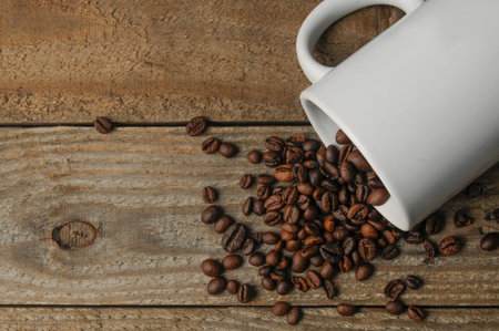 A blank customizable coffee mug on a wooden table with coffee beans and copy space.