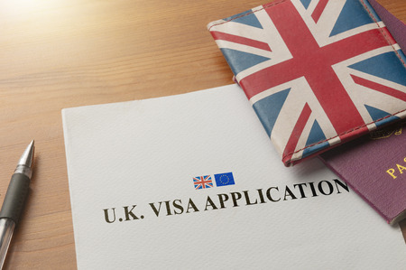 Visa application on desktop with passport and union jack walletの写真素材