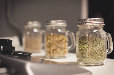 Fresh ground spices in glass jars on the kitchen stoveの写真素材