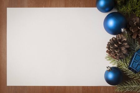 Christmas blue and green decorations on wooden table with big white card as copy spaceの写真素材