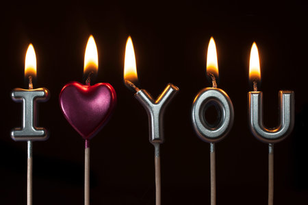 Silver and pink birthday candles forming the phrase I love you on black backgroundの写真素材