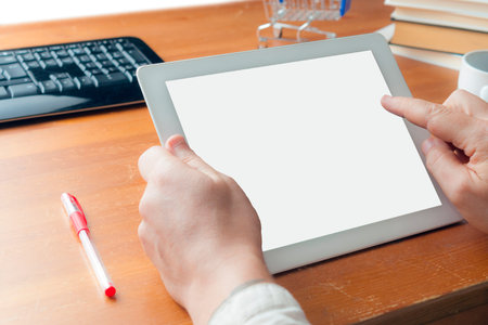 Man in shirt doing online shopping with a blank screen white tablet