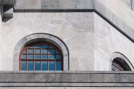 Wood arch windows on marble building reflect blue sky on a sunny day の写真素材