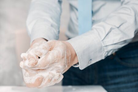 Businessman in blue shirt and tie wash his hands deeply. Hand washing is very important to avoid the risk of contagion from coronaviruse and bacteria.の写真素材