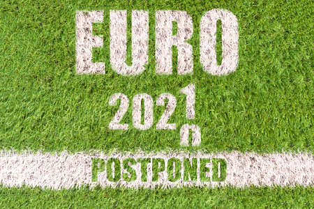 Euro 2020 postponed concept: text that announce that the european soccer tournamente will be postponed to 2021 due to the coronavirus crisis written on an artificial soccer fieldのeditorial素材
