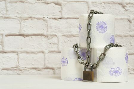 Rolls of toilet paper tied with a chain closed with a padlockの写真素材