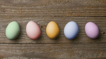 Five colored easter eggs on wooden boardsの写真素材