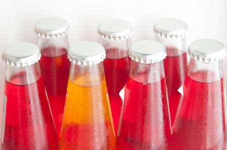 Be different concept: a bottle yellow soft drink between many red bottlesの写真素材