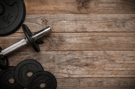 Dumbbell and weight discs on wooden floor