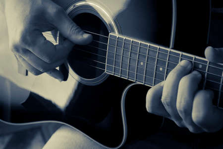 Detail of a man playing an acoustic guitar, duotone colorの写真素材