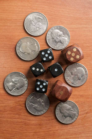 Quarter coins and dice on a wooden tableの写真素材