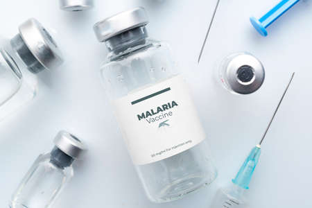 Malaria vaccine concept: vials and syringes on a white planeの写真素材