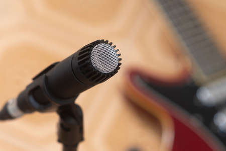 Dynamic microphone with an electric guitar on the backgroundの写真素材